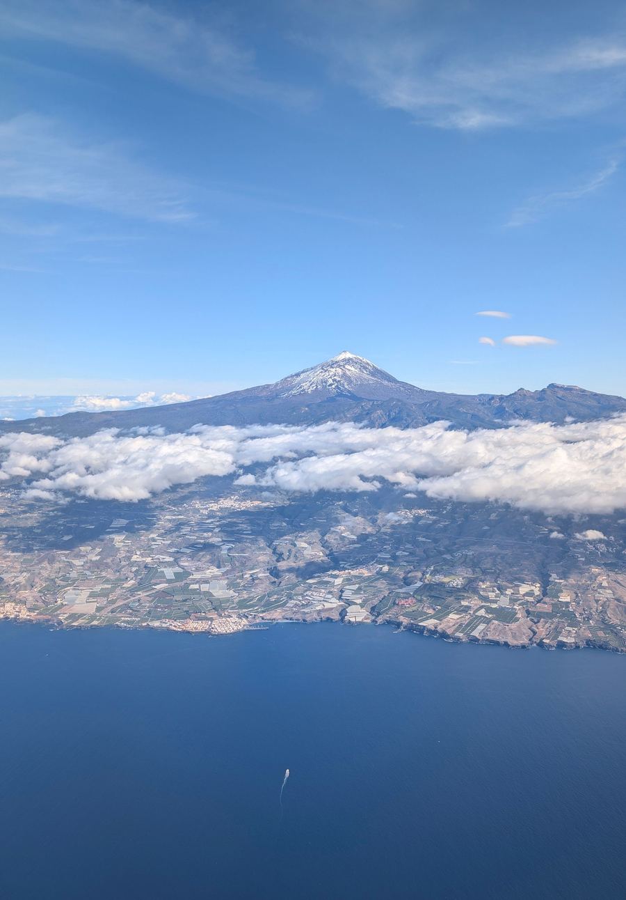 El Teide nevado asomando entre las nubes, visto desde el aire
